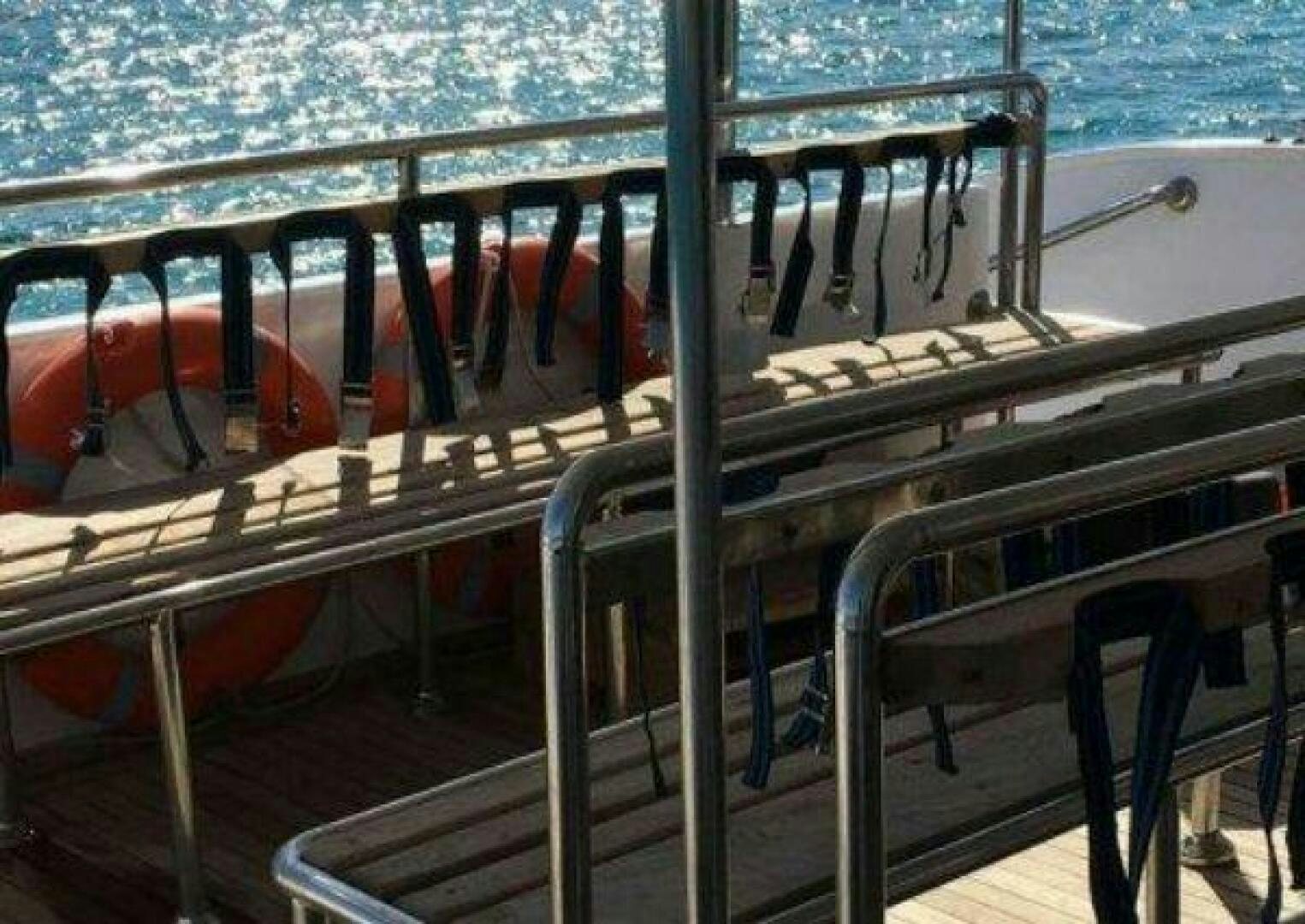 a deck with a railing and a body of water in the background aboard RED SEA QUEEN Yacht for Sale