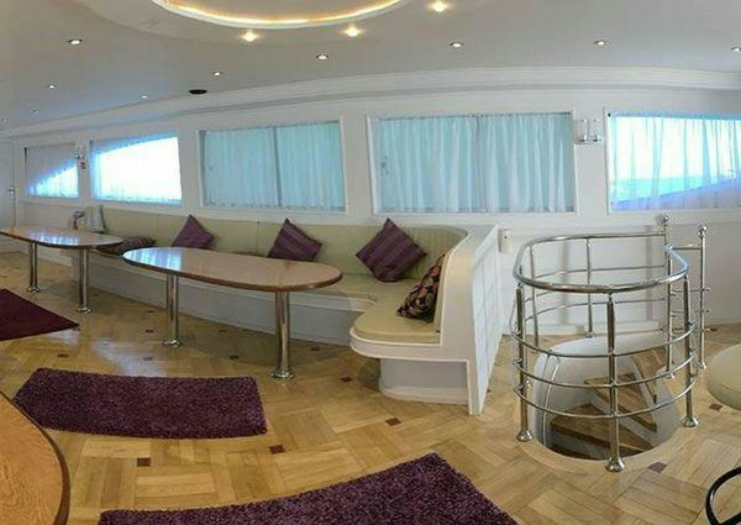 a living room with a table and chairs aboard RED SEA QUEEN Yacht for Sale