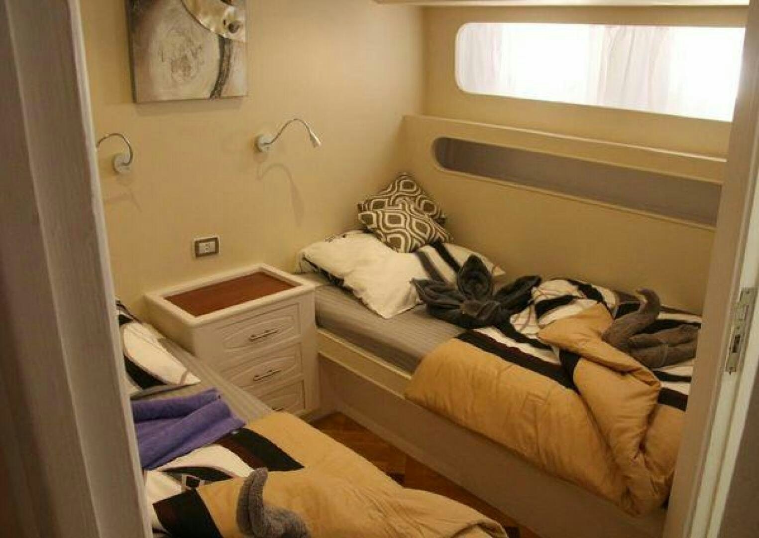 a bedroom with a bed and a dresser aboard RED SEA QUEEN Yacht for Sale