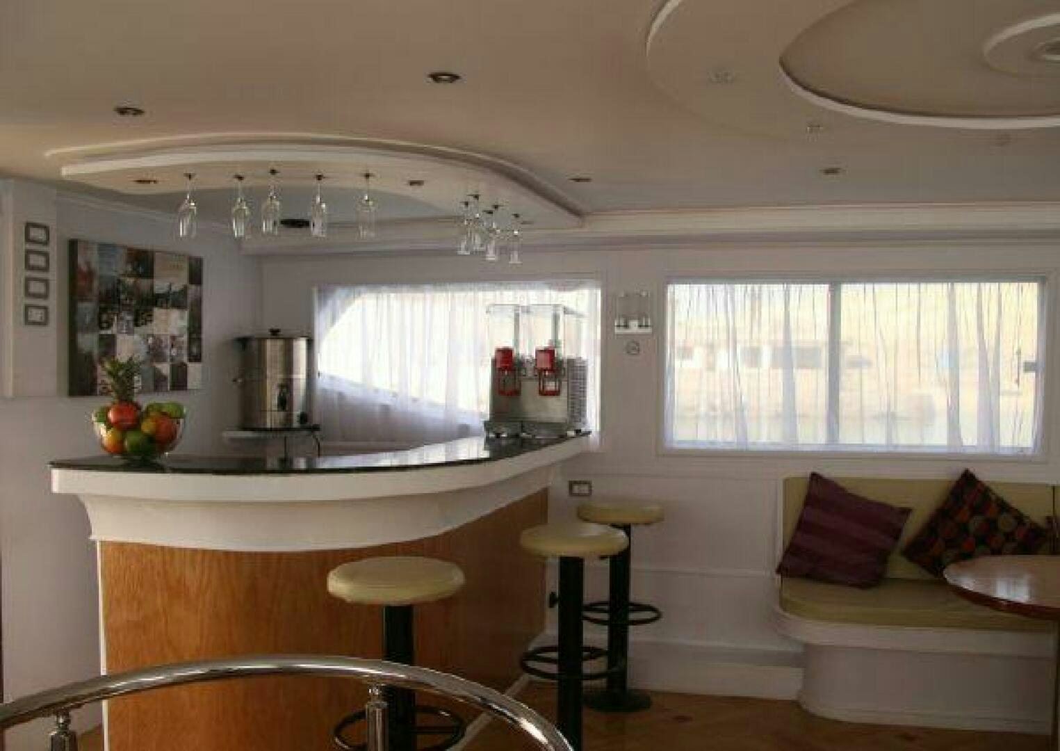a kitchen with a table and stools aboard RED SEA QUEEN Yacht for Sale