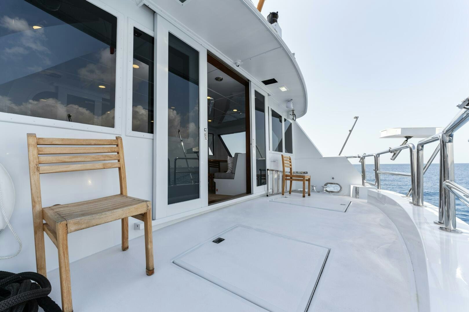 a white room with a chair and a table on a snowy day aboard ARIES Yacht for Sale