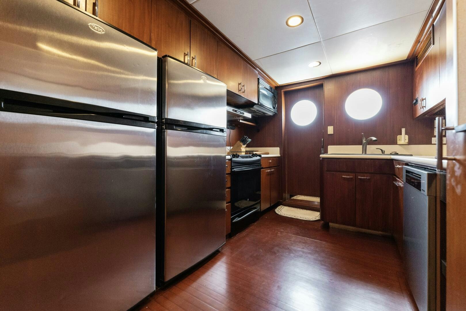 a kitchen with a stainless steel refrigerator aboard ARIES Yacht for Sale