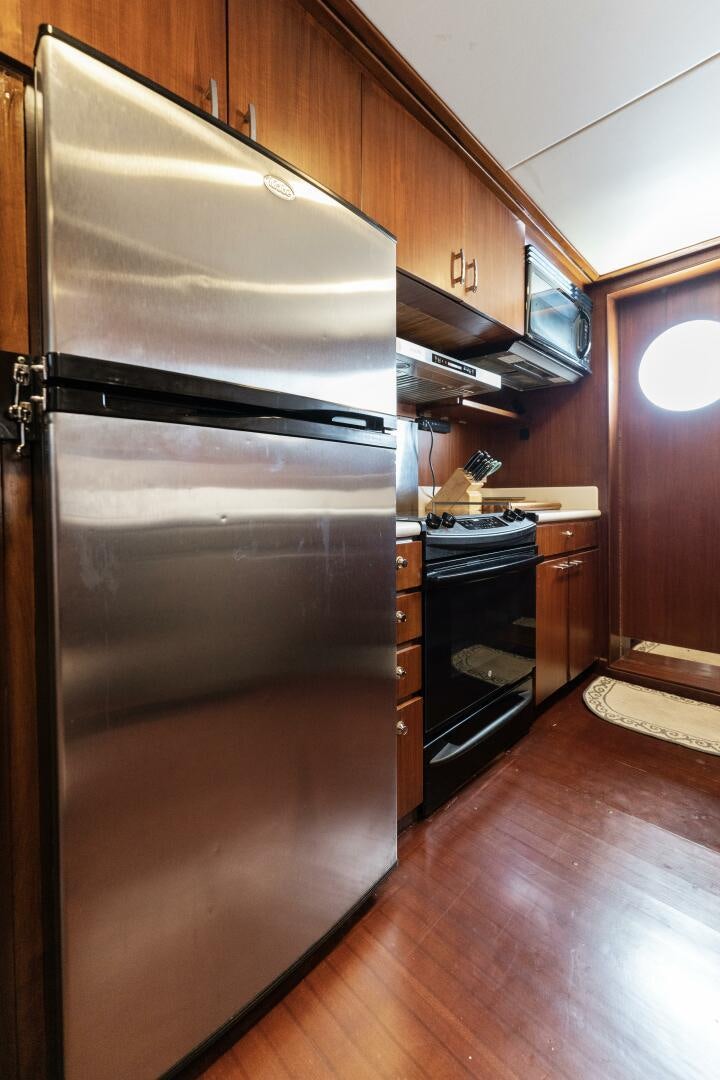a stainless steel refrigerator in a kitchen aboard ARIES Yacht for Sale