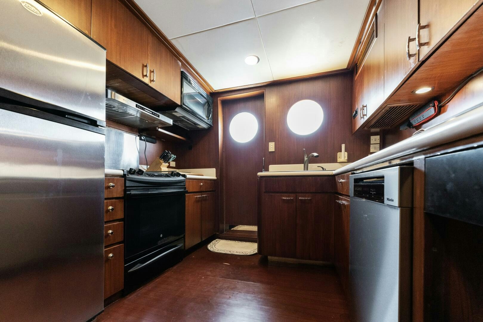 a kitchen with wooden cabinets aboard ARIES Yacht for Sale