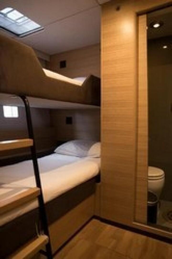 a small room with a bed and a mirror aboard KAILUA Yacht for Sale