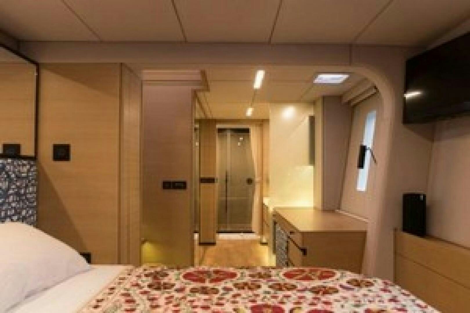 a room with a bed and desk aboard KAILUA Yacht for Sale
