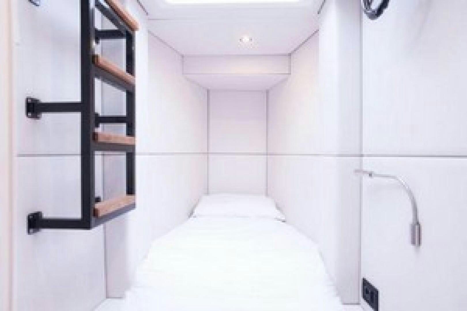a white room with a ladder and a bed aboard KAILUA Yacht for Sale