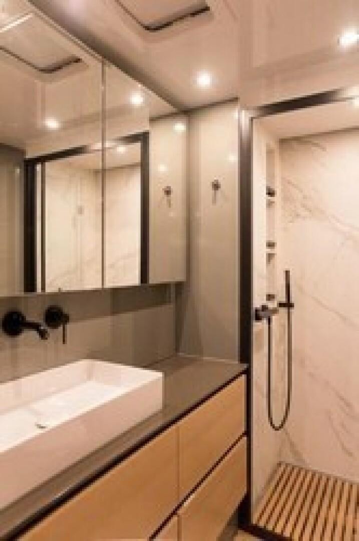 a bathroom with a bathtub and sinks aboard KAILUA Yacht for Sale