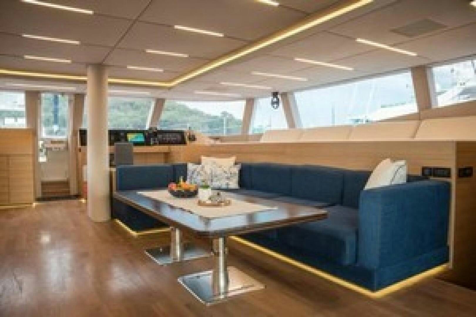 a room with a table and couch aboard KAILUA Yacht for Sale