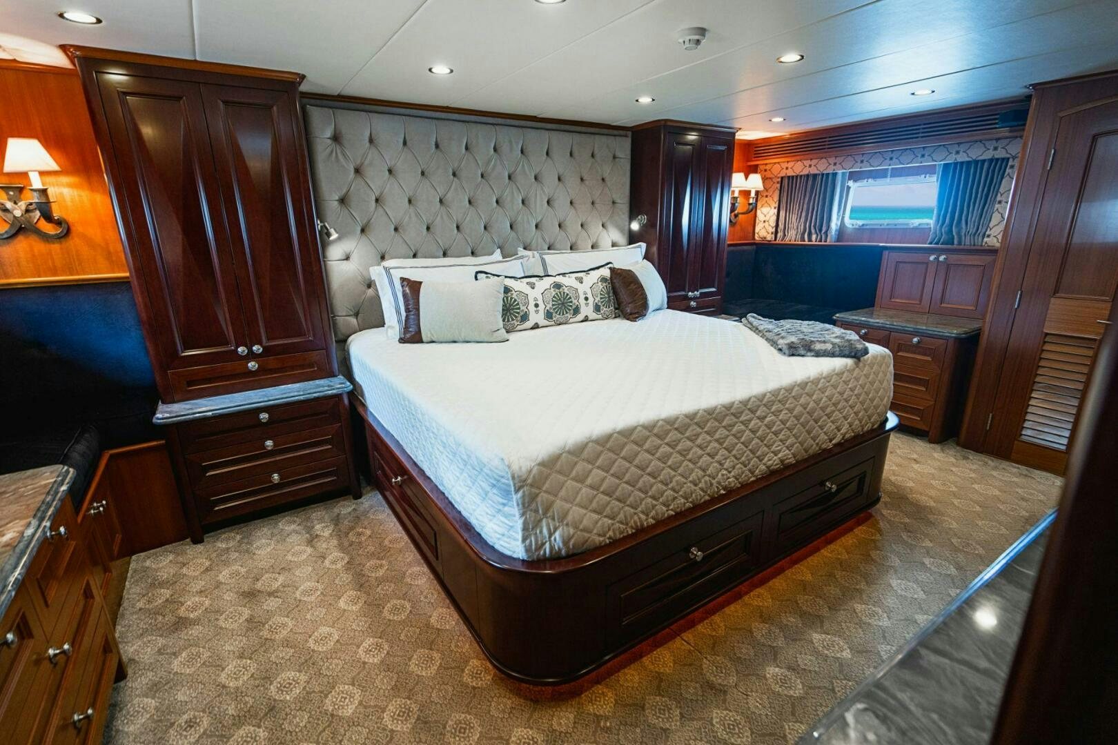a bedroom with a bed and a dresser aboard MOONSHOT Yacht for Sale