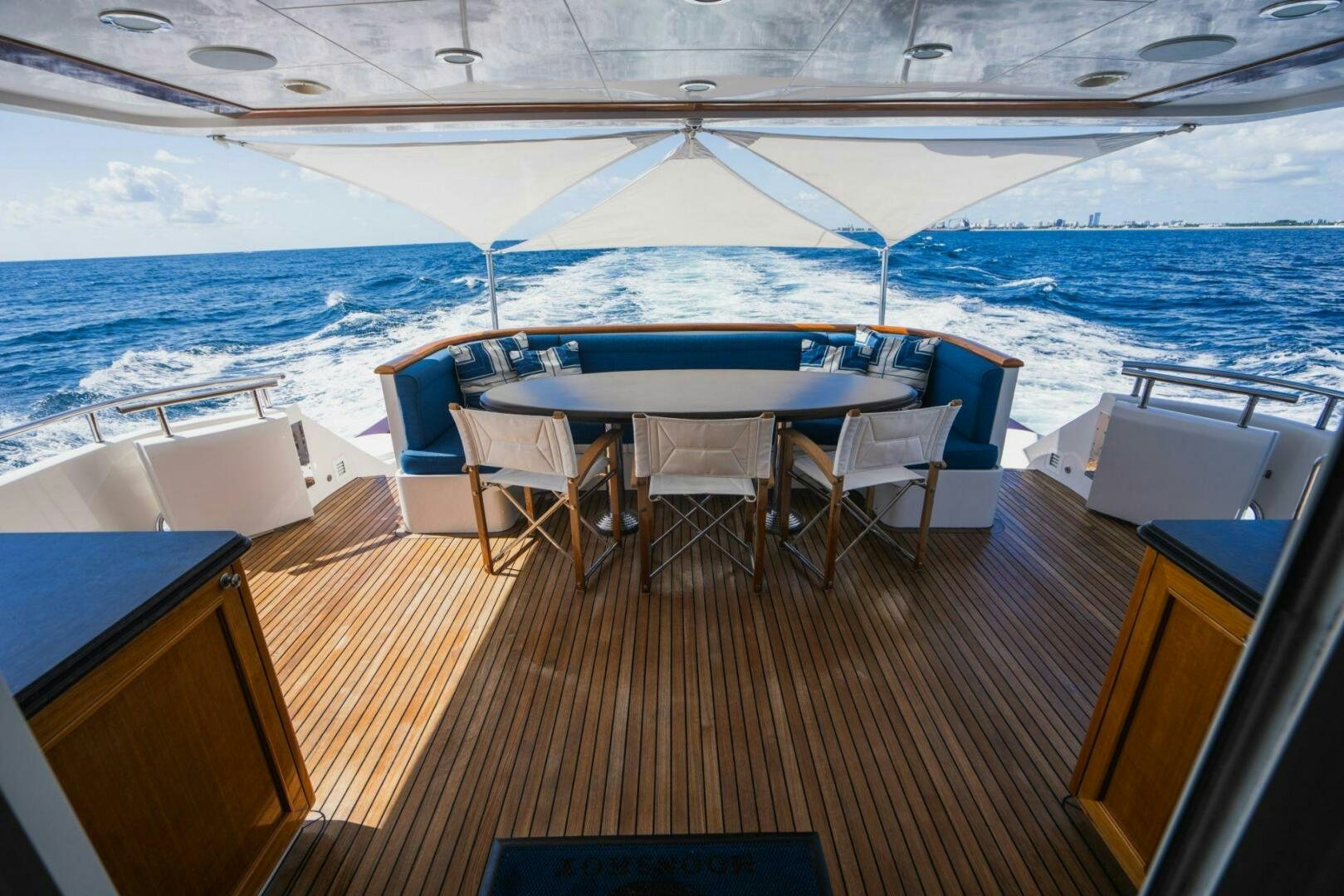 a deck with a table and chairs on it aboard MOONSHOT Yacht for Sale