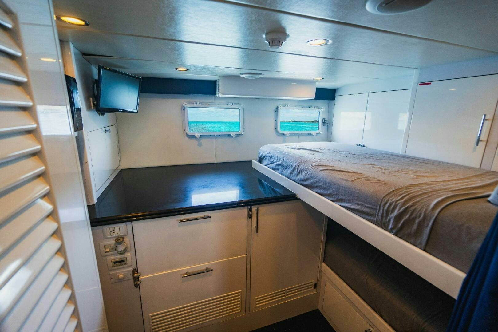 a room with a bed and a desk aboard MOONSHOT Yacht for Sale