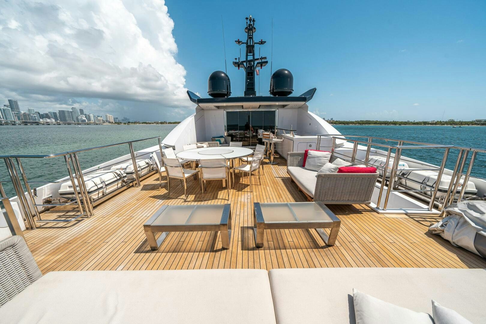 a deck with tables and chairs on it by the water aboard LEUDIN I Yacht for Sale