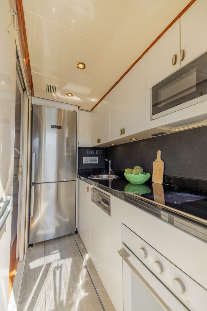 a kitchen with a stainless steel refrigerator aboard BOULOS Yacht for Sale
