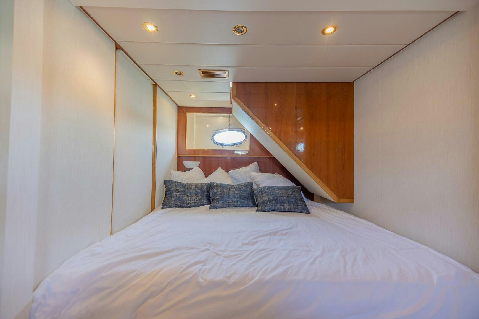 a bed with a white sheet and a wooden headboard aboard BOULOS Yacht for Sale