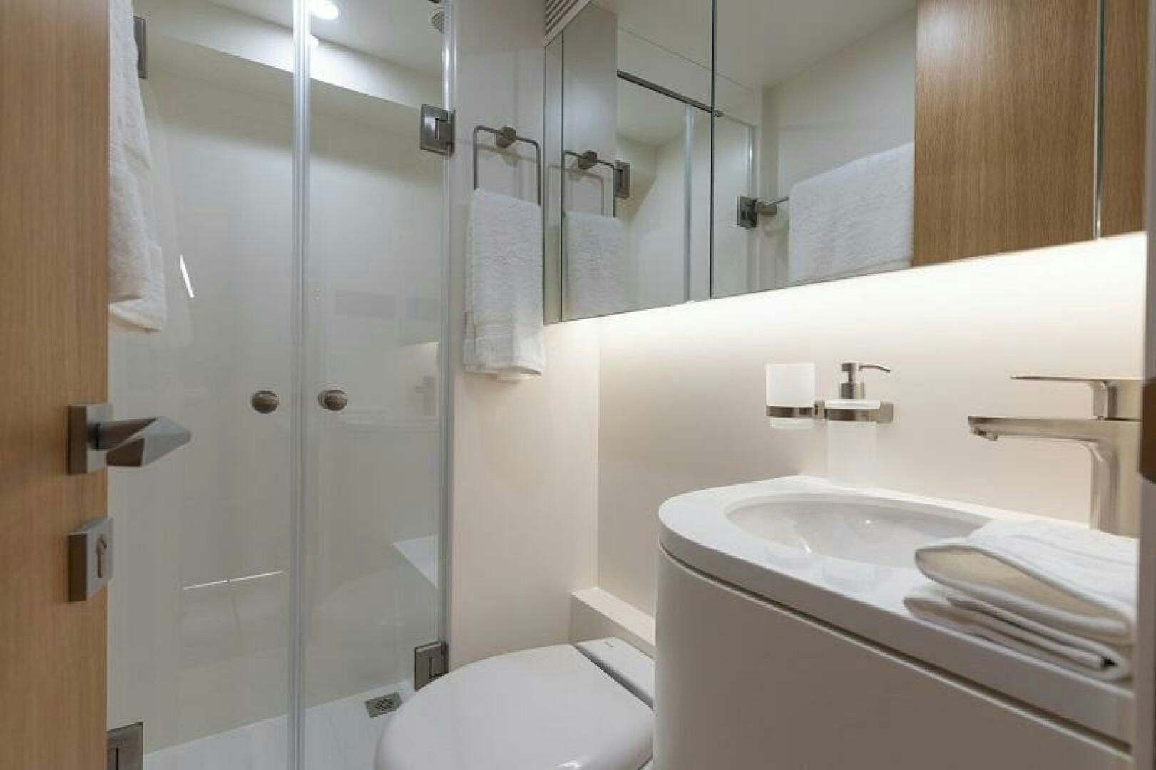 a bathroom with a glass shower door aboard WIGGLE ROOM Yacht for Sale