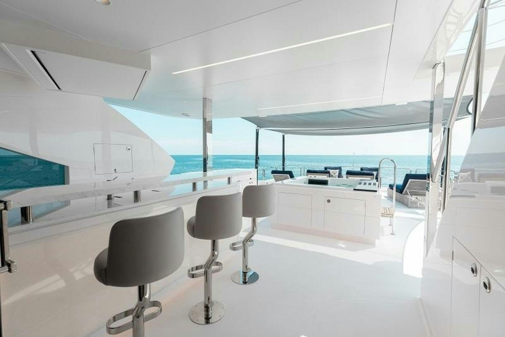 a room with white chairs and a table with a glass ceiling aboard WIGGLE ROOM Yacht for Sale
