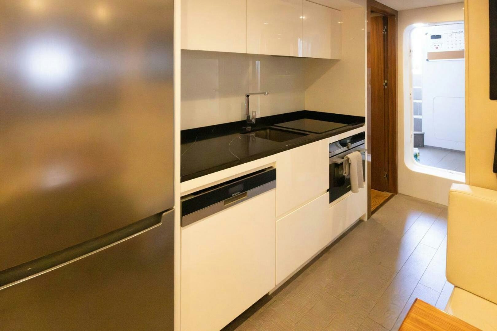 a kitchen with white cabinets aboard LADY CAROLINE Yacht for Sale
