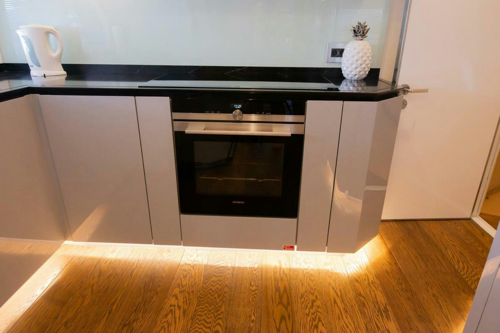 a kitchen with a black stove aboard LADY CAROLINE Yacht for Sale