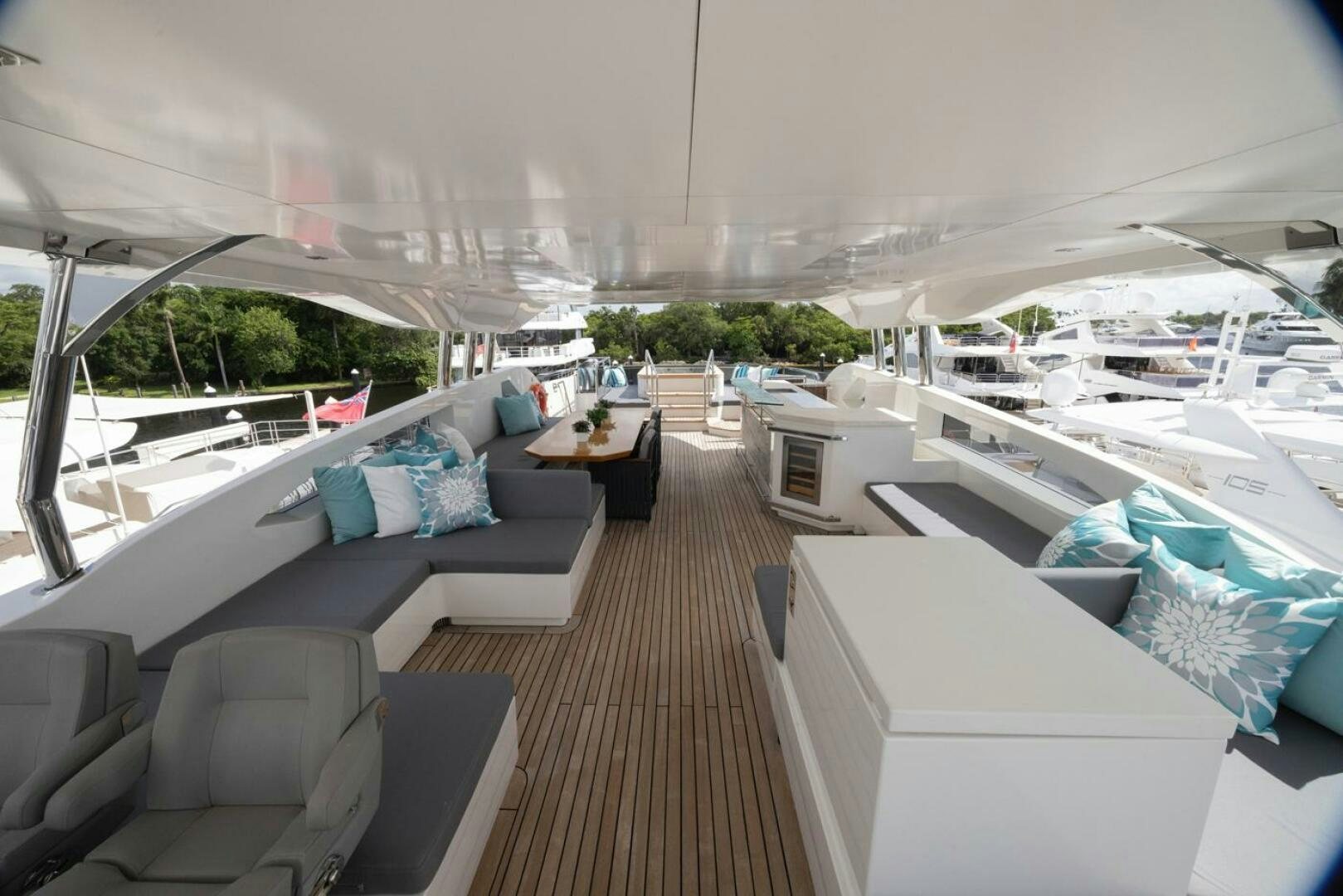 a large boat with a deck and a couch and a table with chairs aboard LADY CAROLINE Yacht for Sale