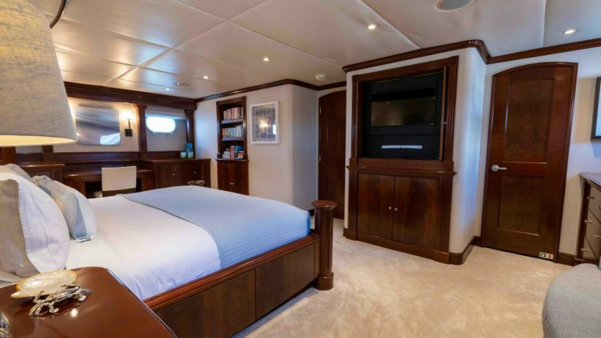 a bedroom with a bed and a desk aboard ODIN Yacht for Sale