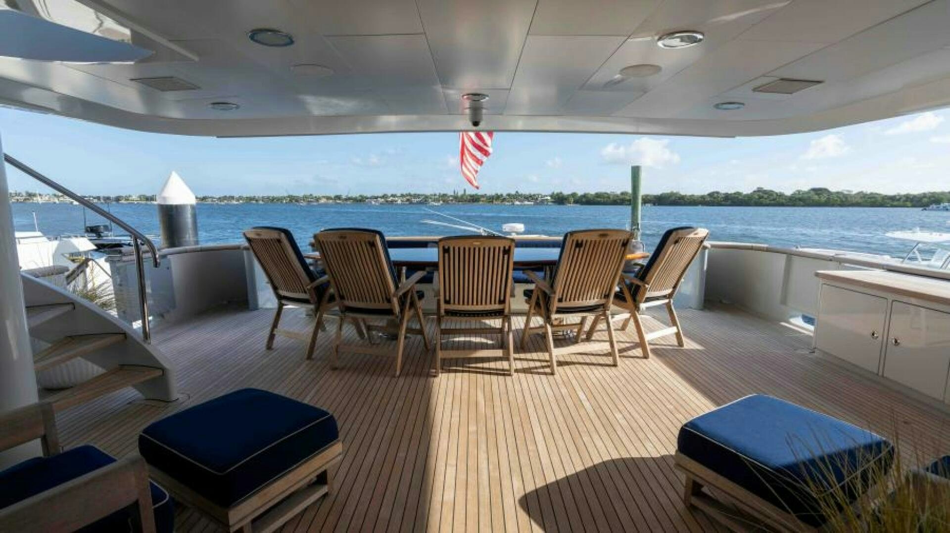 a deck with chairs and tables on it aboard ODIN Yacht for Sale