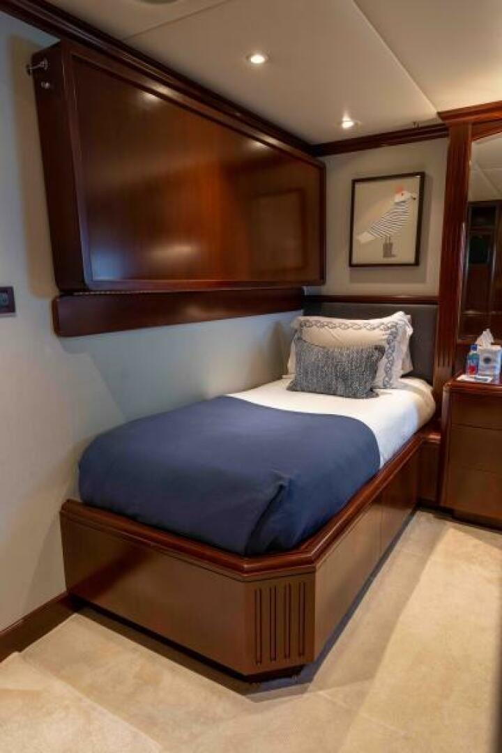 a bed with a blue blanket aboard ODIN Yacht for Sale