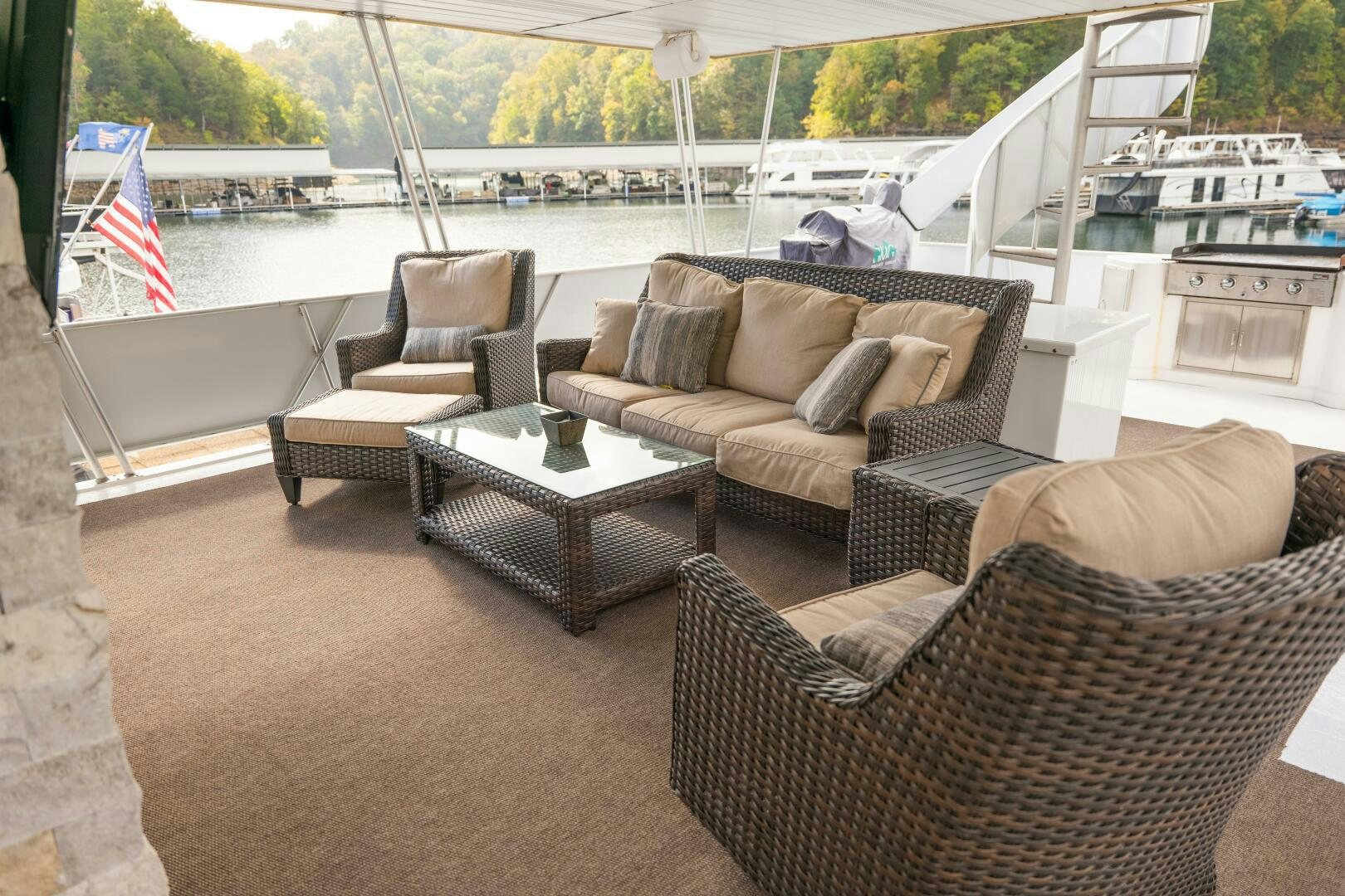 a couple of couches and a table on a patio by a body of water aboard SUNSTAR Yacht for Sale