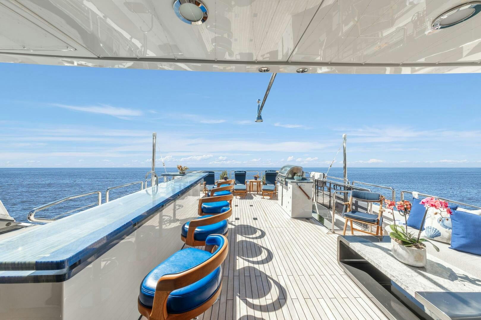 a deck with chairs and a railing overlooking a body of water aboard DRINKABILITY Yacht for Sale