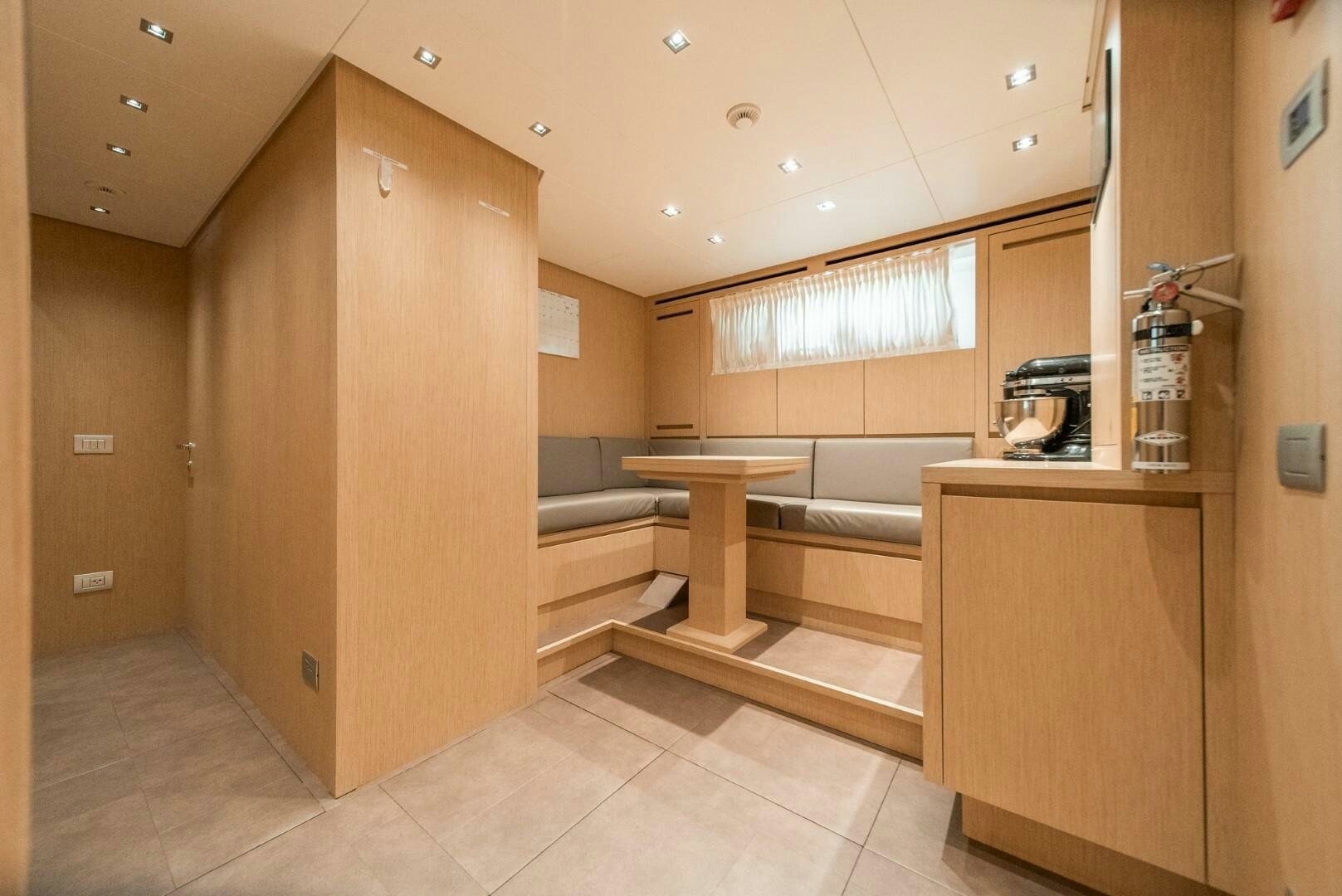 a room with a table and a bench aboard GENOA Yacht for Sale