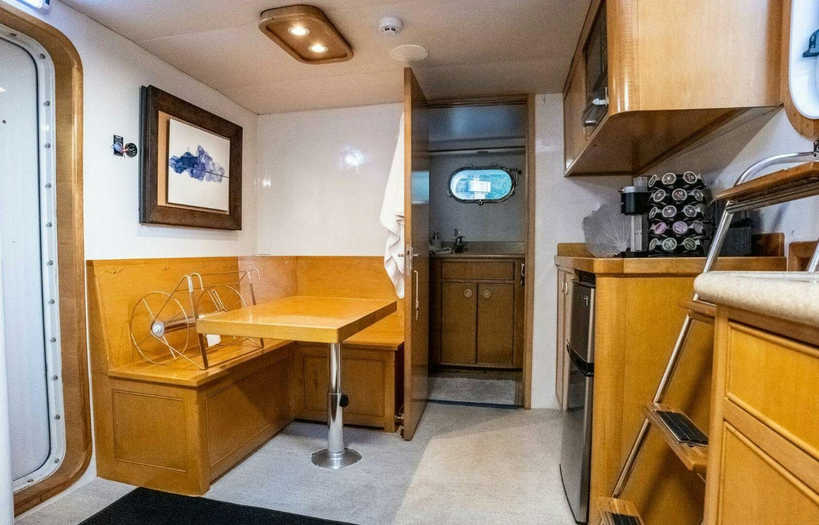 a kitchen with a table and a bench aboard DOZER Yacht for Sale