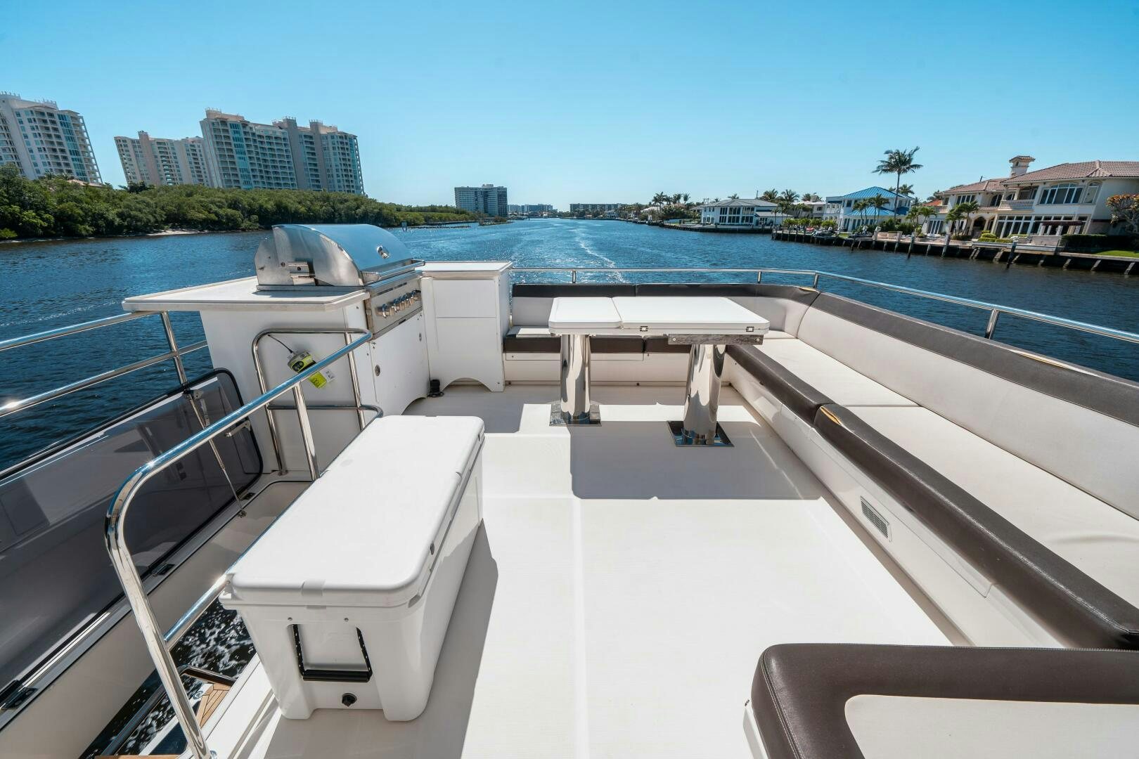 a deck with chairs and tables on it by a body of water aboard OPTIMUS PRIME Yacht for Sale