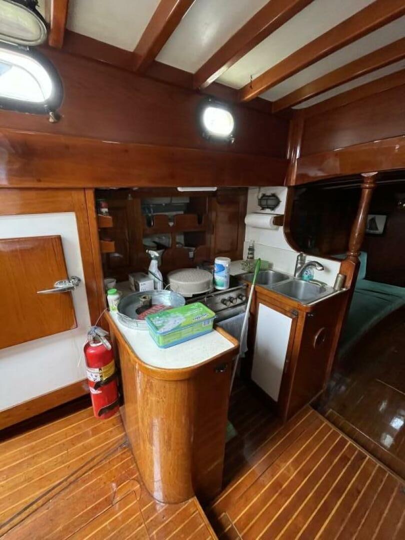 a kitchen with wooden cabinets aboard CURLEW Yacht for Sale