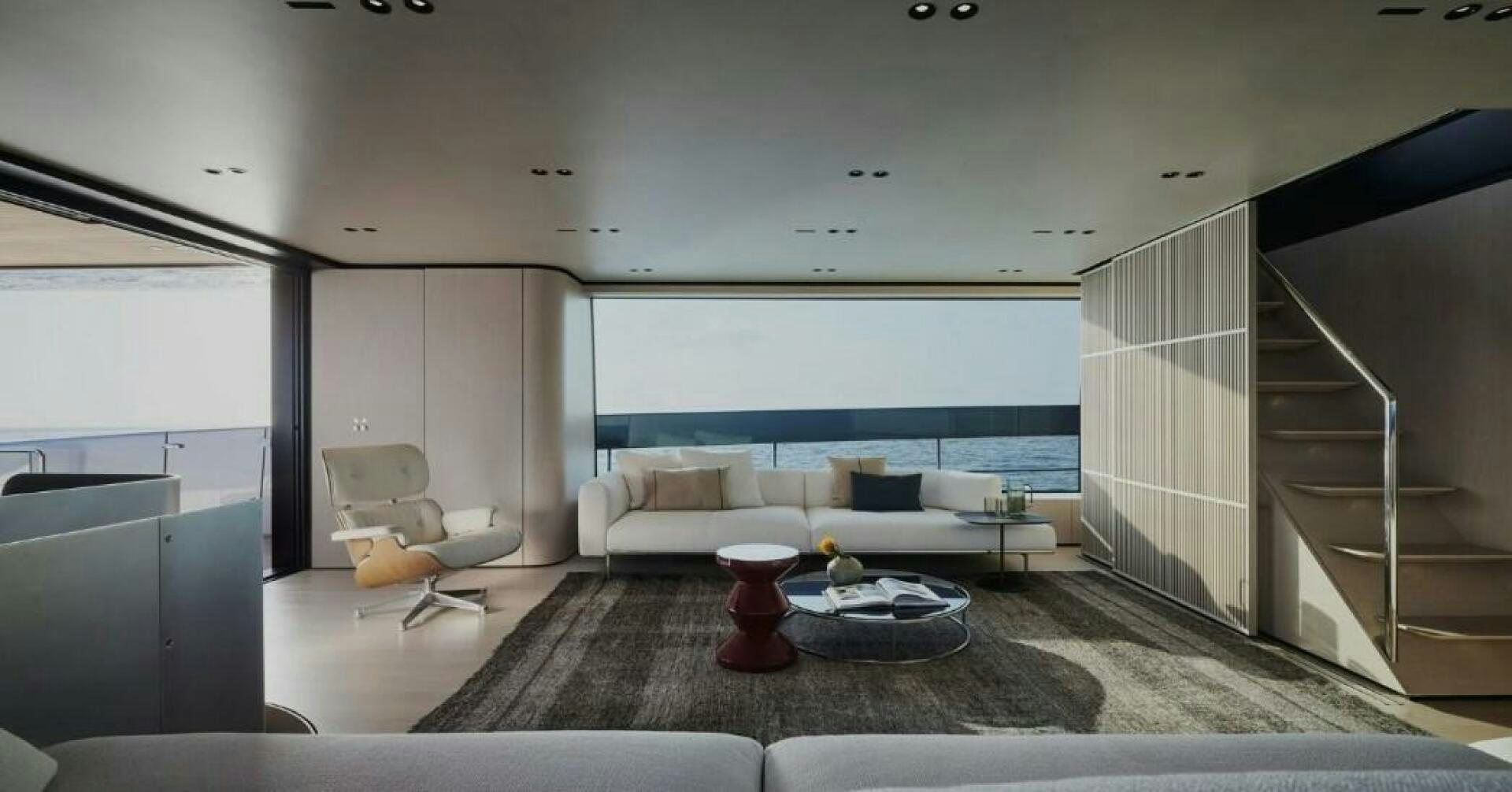 a modern looking living room with a glass coffee table and a view of the ocean aboard SX100 Yacht for Sale