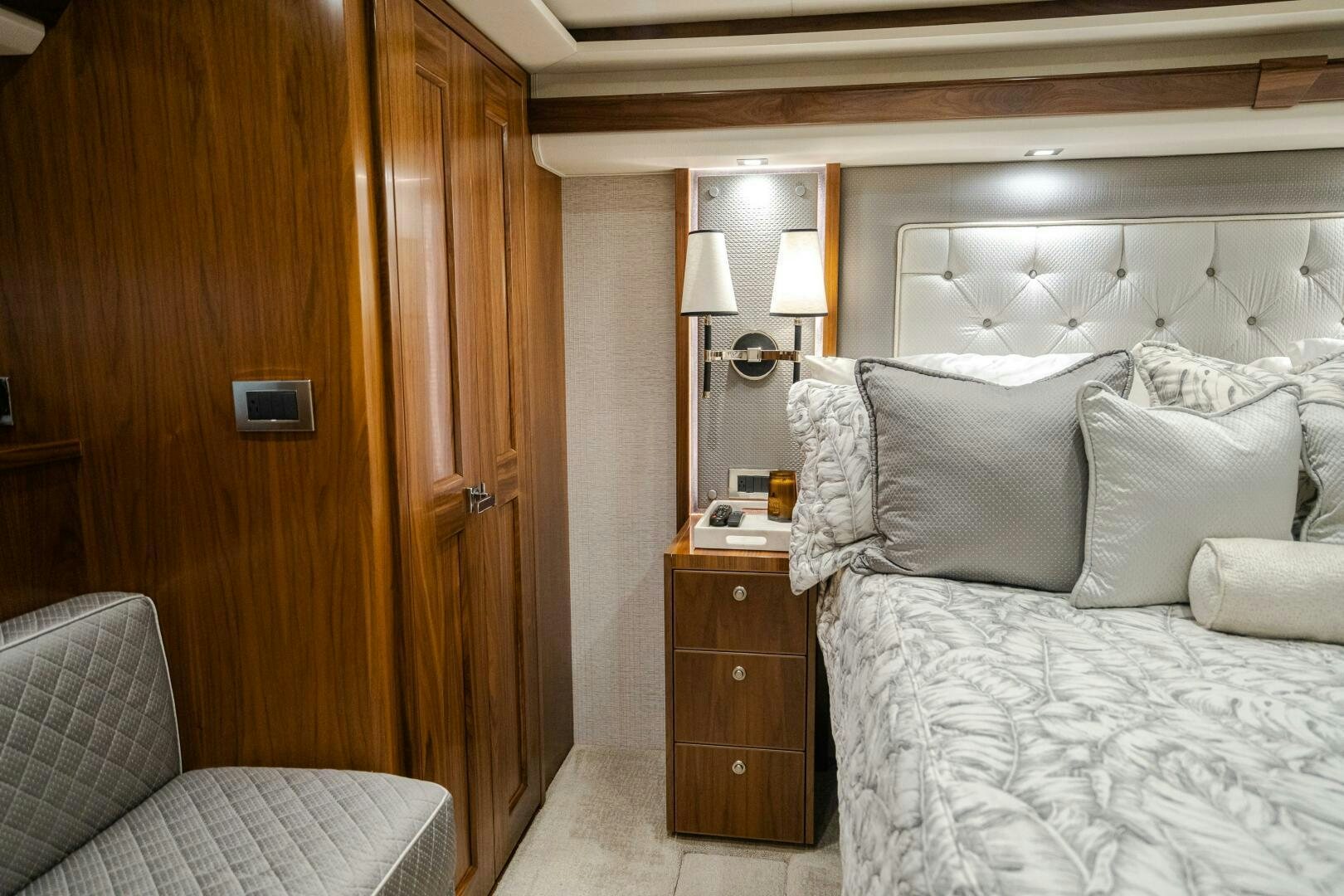 a bed with a white comforter and a wooden door aboard HOORAY Yacht for Sale