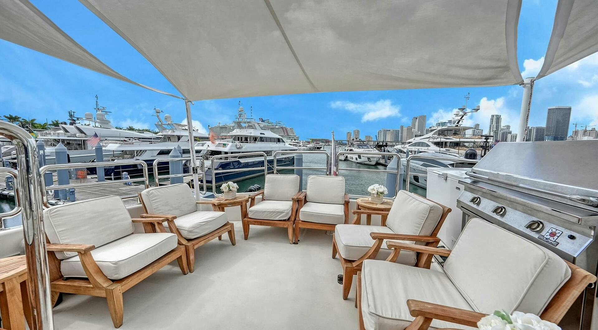 a room with a table chairs and a large ship in the background aboard FANTASEA Yacht for Sale
