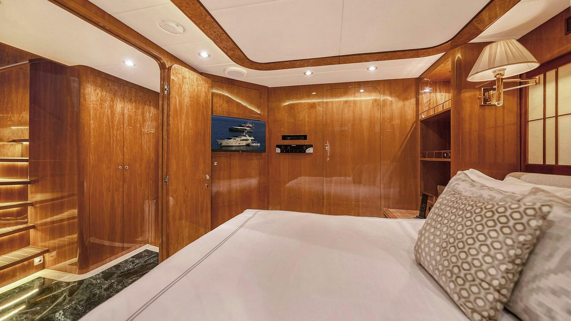 a bed with a white sheet and a wooden wall aboard FANTASEA Yacht for Sale