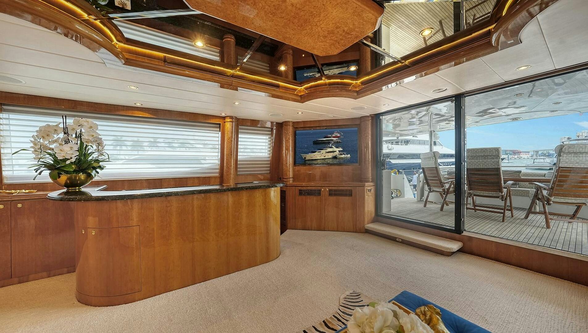 a room with a wood table and chairs and a large window aboard FANTASEA Yacht for Sale