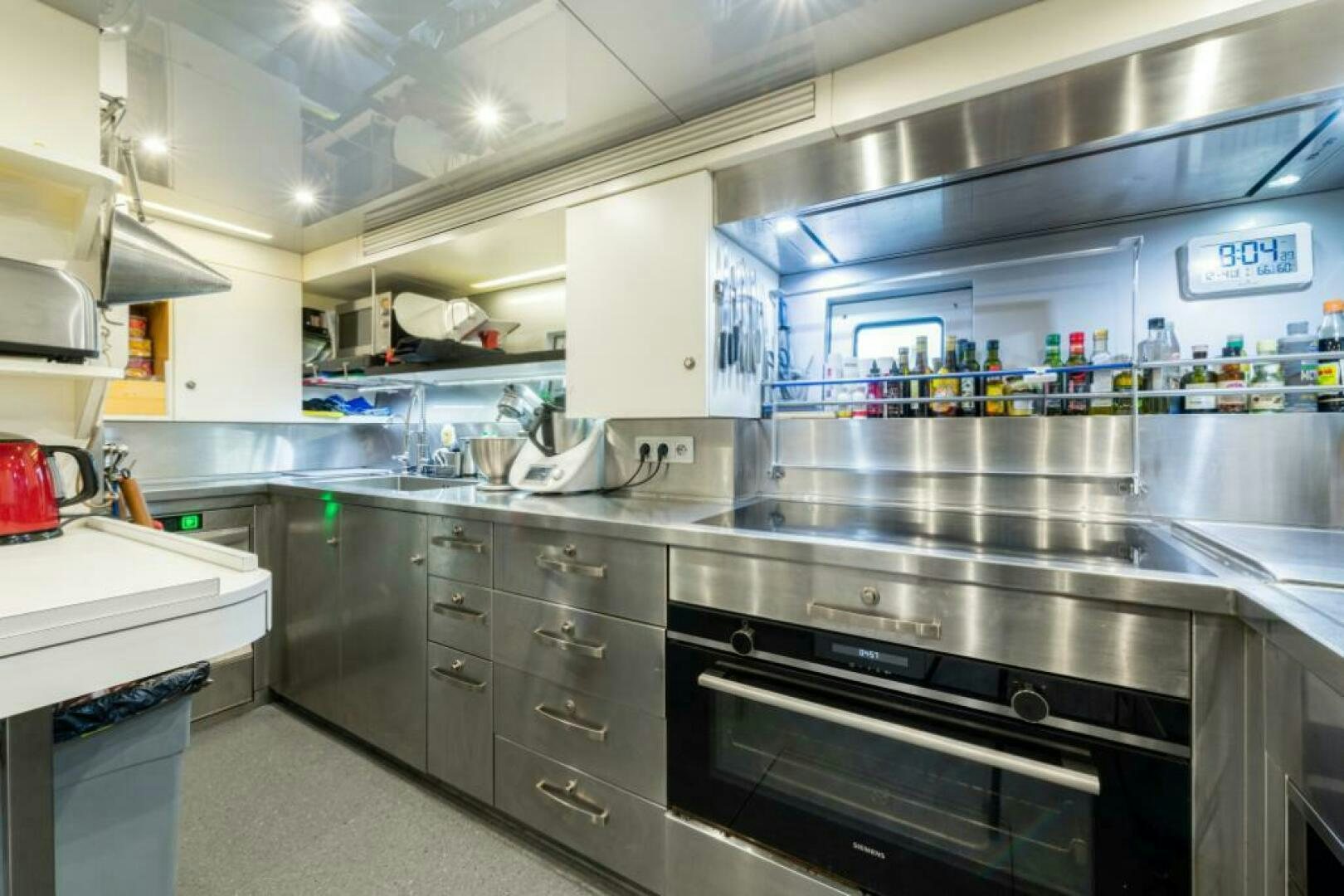 a kitchen with a stove and shelves aboard MOUSETRAP Yacht for Sale
