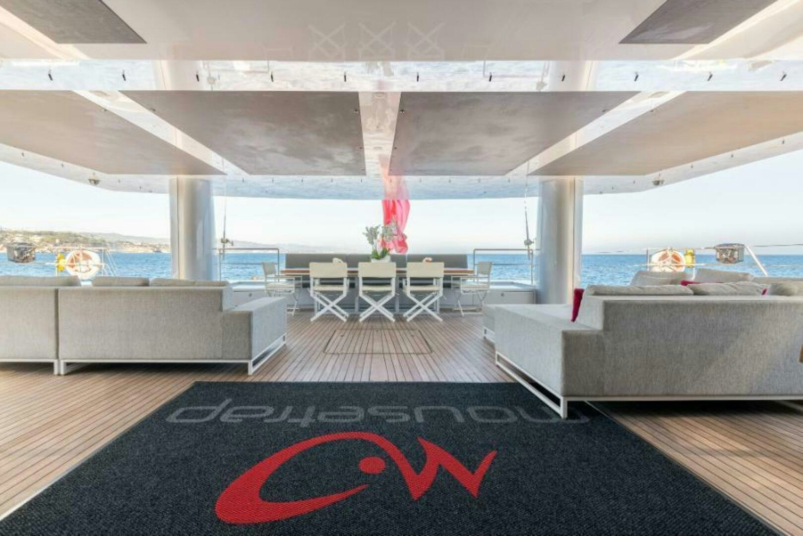 a person standing on a white couch in a large room with a large window aboard MOUSETRAP Yacht for Sale