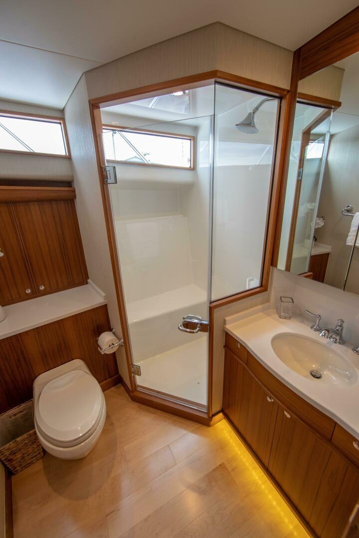 a bathroom with a glass shower door aboard PRIVATEER Yacht for Sale