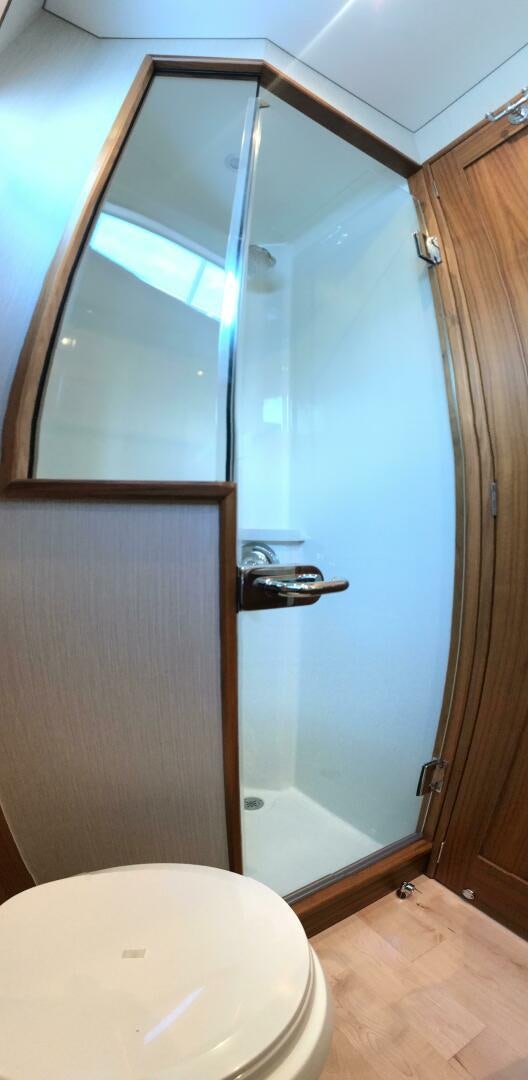 a bathroom with a toilet and a wooden door aboard PRIVATEER Yacht for Sale
