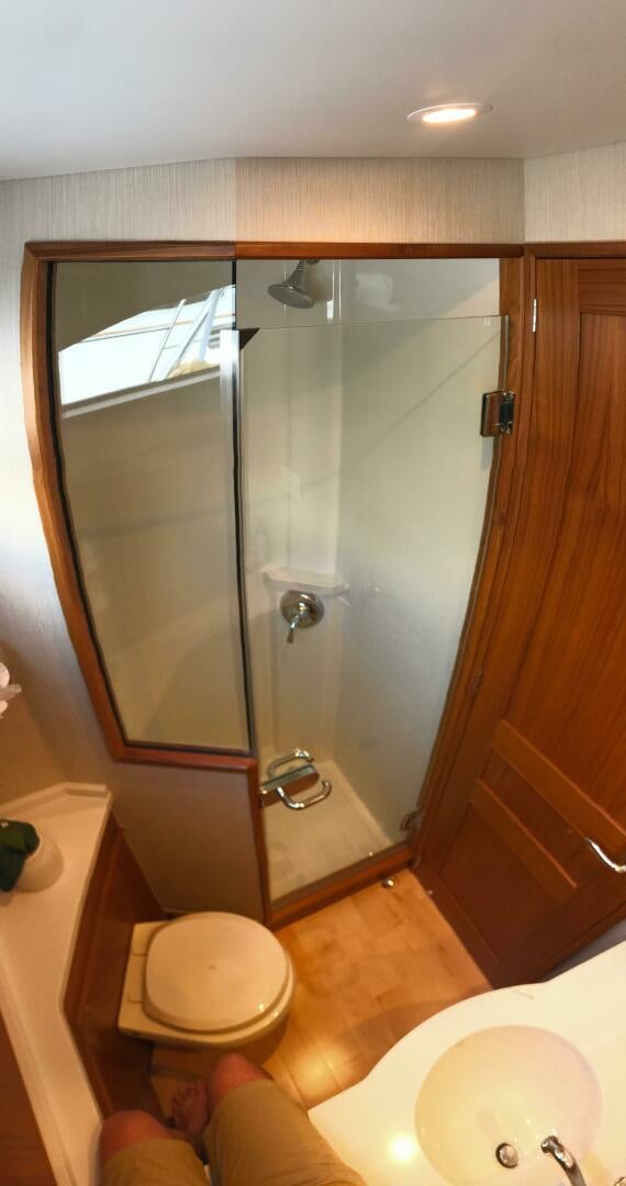 a bathroom with a glass shower door aboard PRIVATEER Yacht for Sale
