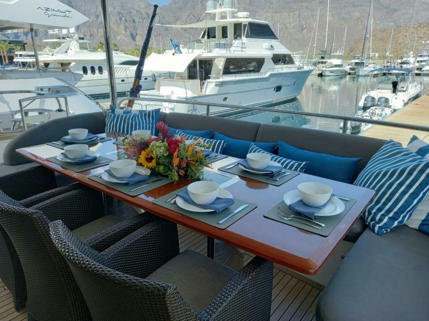 a table with plates and flowers on it next to a boat aboard PRINCESS TWO Yacht for Sale