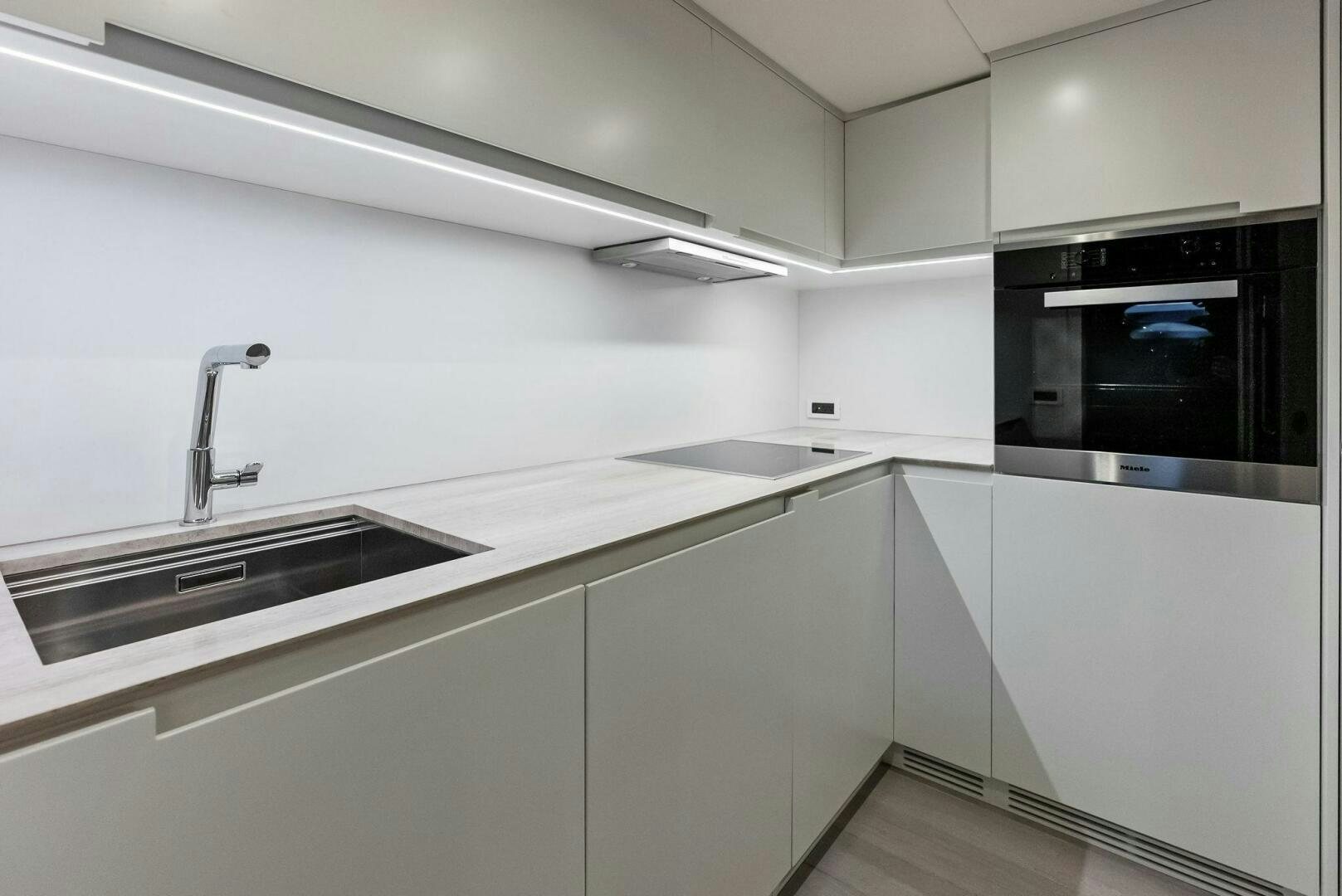a kitchen with white cabinets aboard OUR TRADE Yacht for Sale
