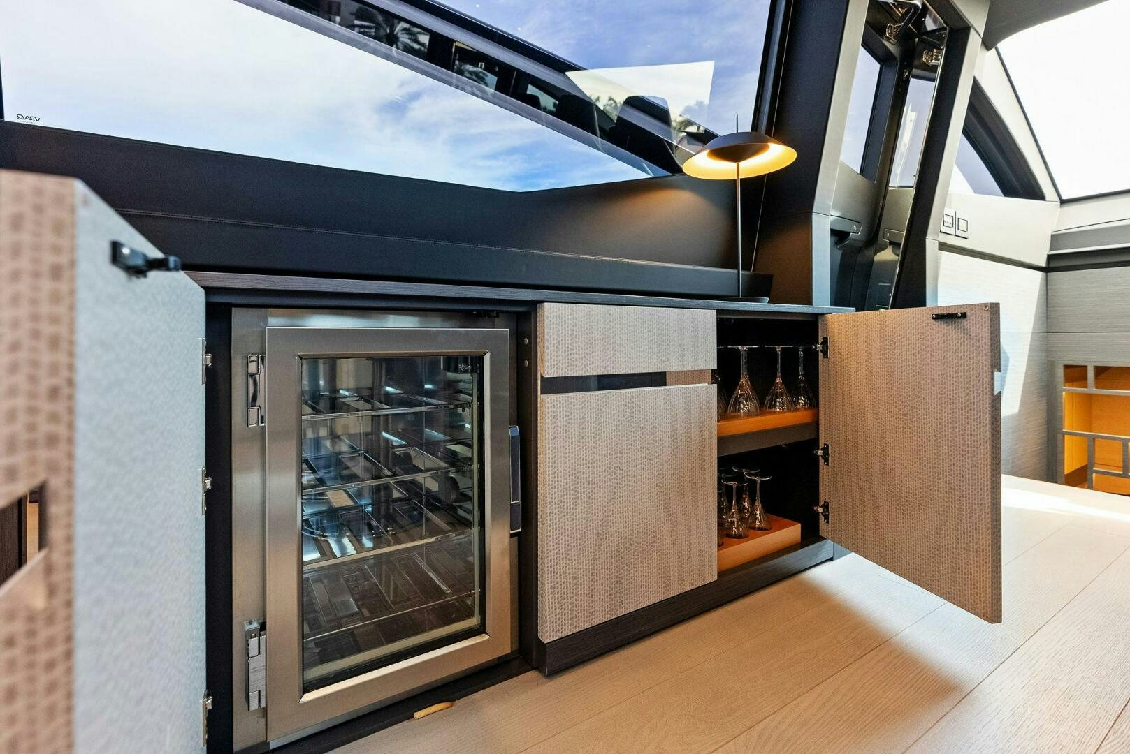 a room with a large glass door and a glass wall with a glass door and a wood floor aboard OUR TRADE Yacht for Sale