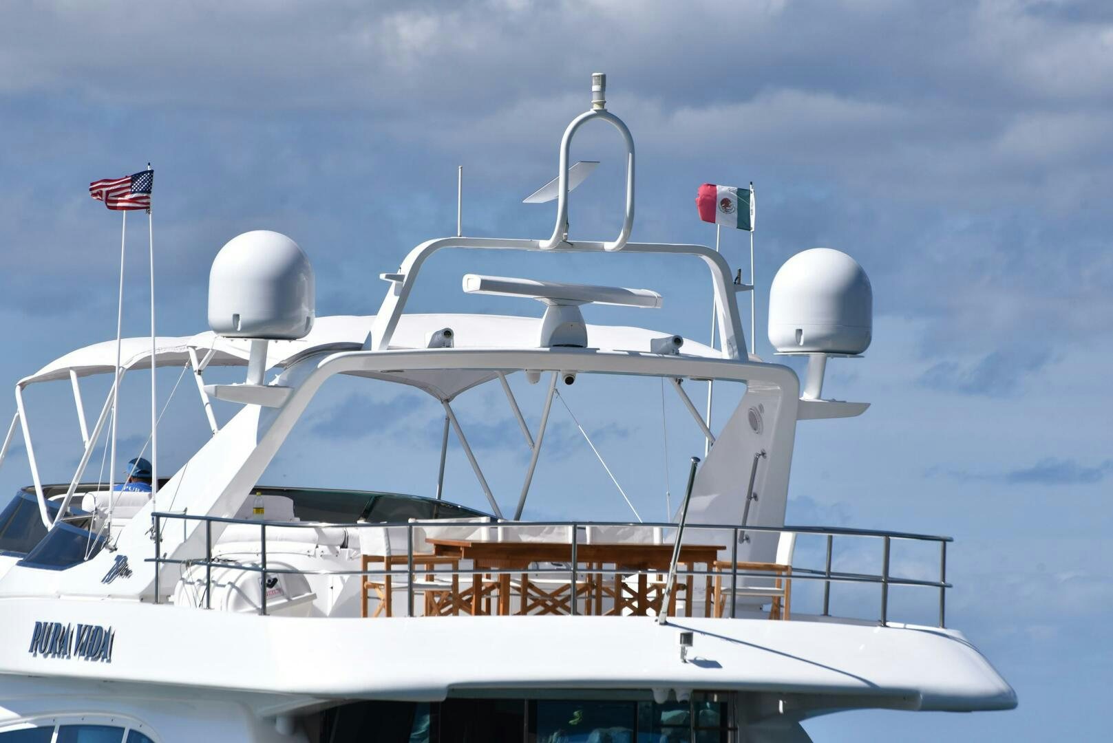 a boat with a flag on the front aboard PURA VIDA  Yacht for Sale