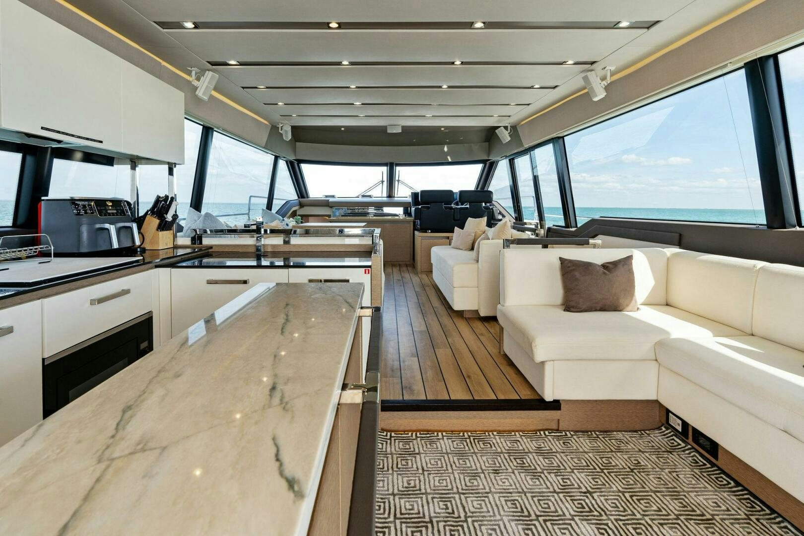 a large living room with a kitchen and a large window aboard PRESTIGE WORLDWIDE Yacht for Sale