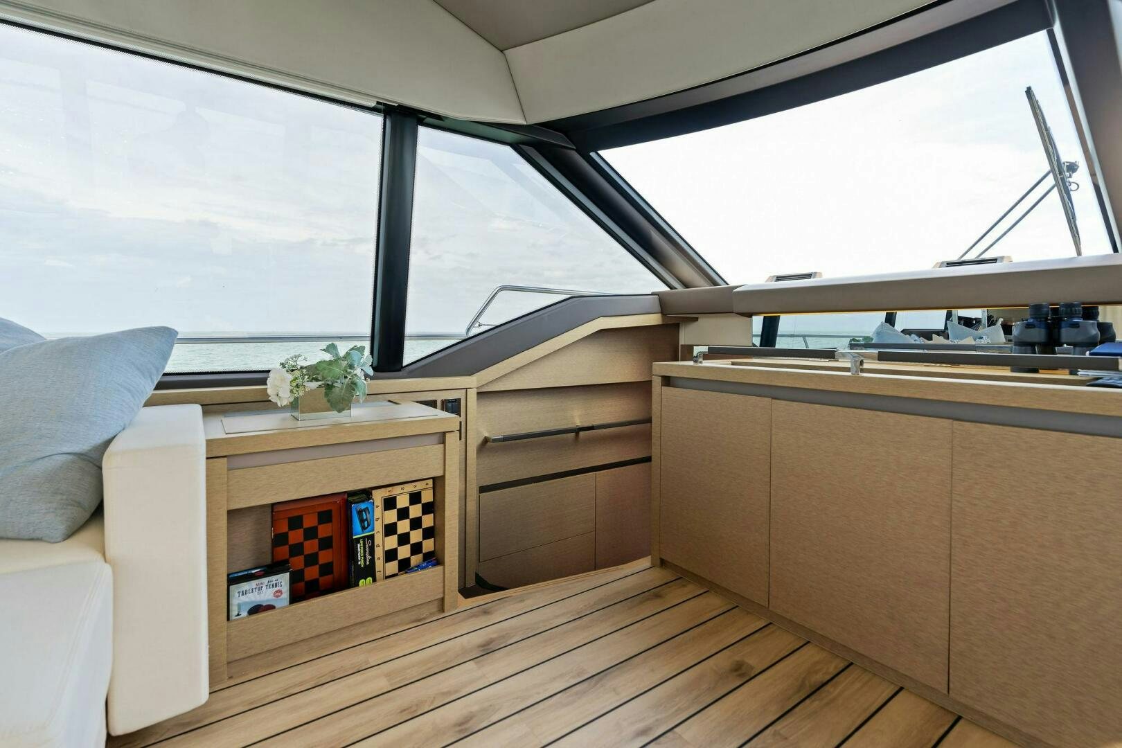 a room with a wood floor and a window with a plant on the side aboard PRESTIGE WORLDWIDE Yacht for Sale
