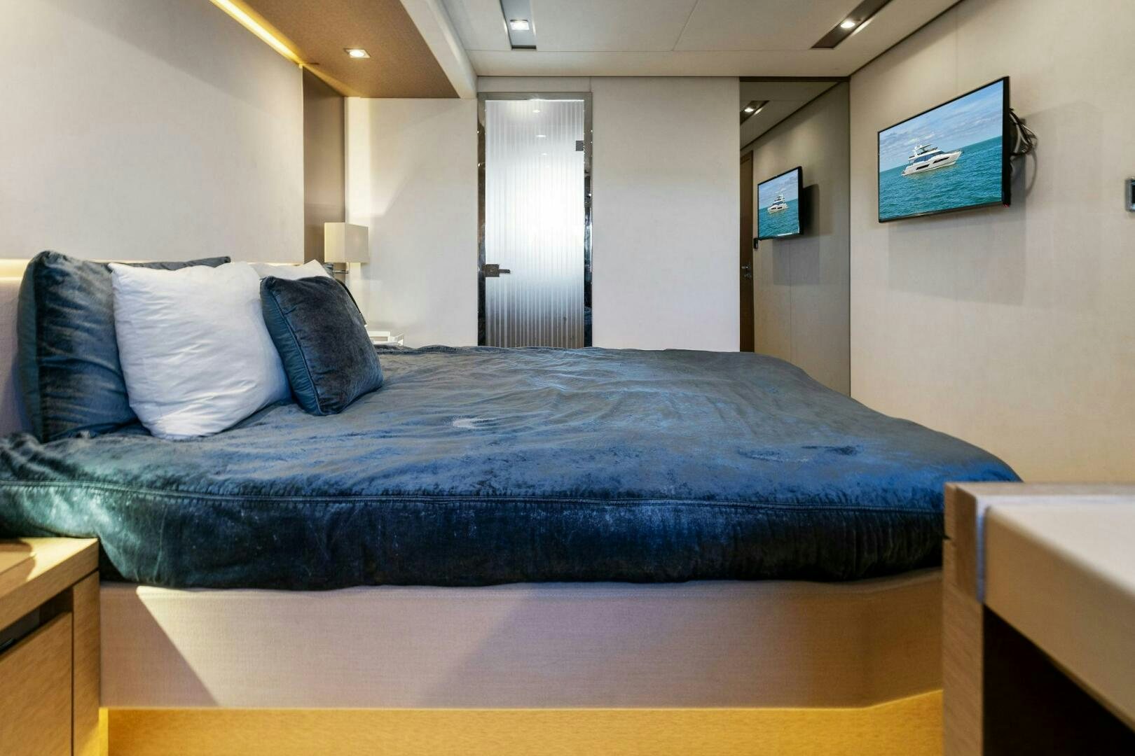 a bed with blue sheets aboard PRESTIGE WORLDWIDE Yacht for Sale